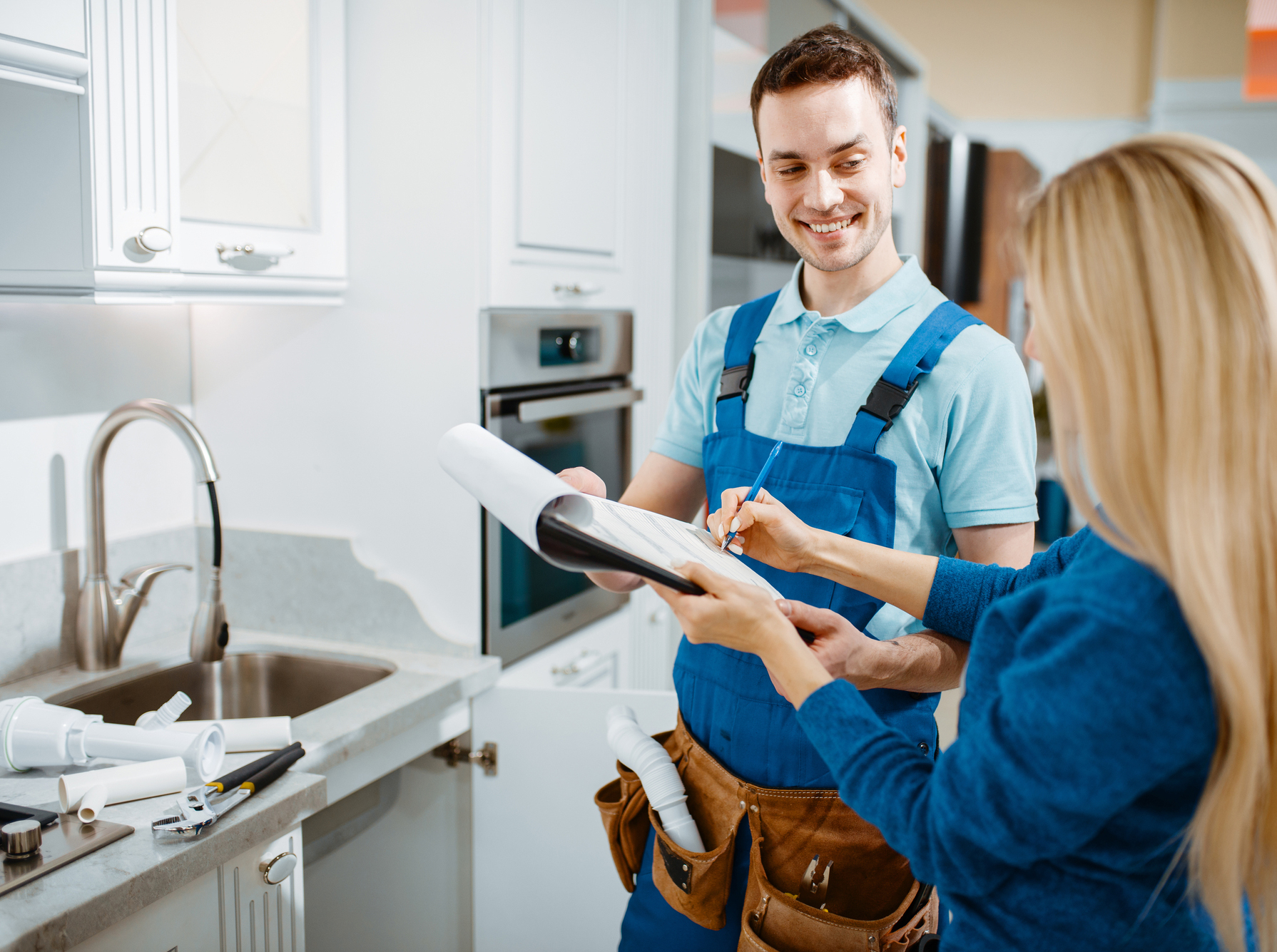 Male Plumber And Female Customer In The Kitchen